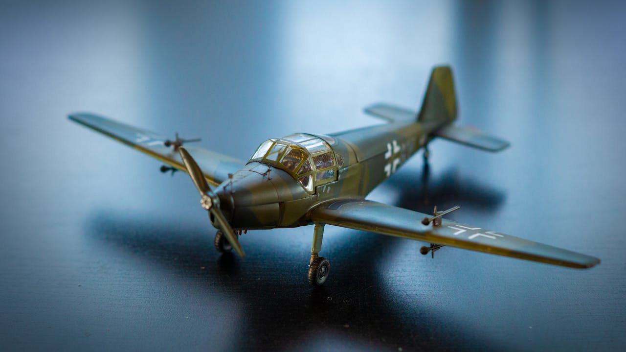 services-03 Close-up of a realistic model airplane with propeller on a dark surface, showcasing intricate details.