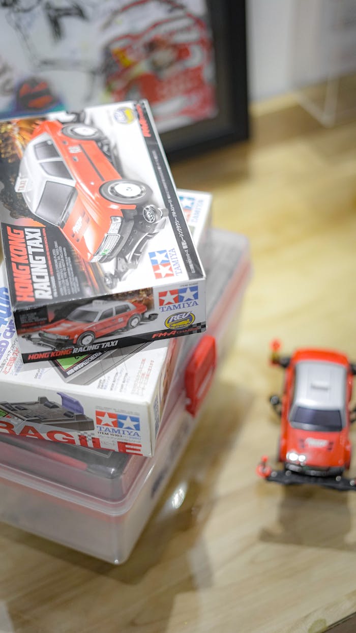 Close-up of a red toy car kit box on a wooden surface with model car.