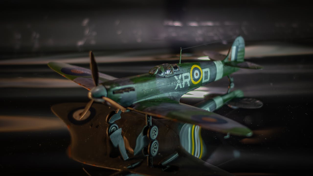 who-we-are Detailed close-up of a green vintage airplane model with markings, focus on craftsmanship.